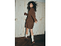 Femme portant une robe en maille marron, des chaussettes plissées blanches et des chaussures compensées marron.