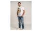 Homme en t-shirt blanc imprimé palmiers et jean, souriant.