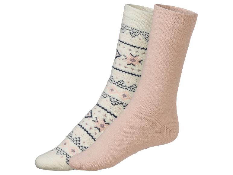 Deux paires de chaussettes: une avec un motif géométrique, l'autre unie rose.