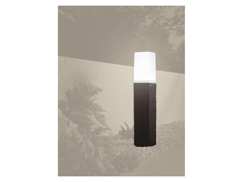 Lampe de jardin en forme de pilier tressé éclairant un chemin de gravier.