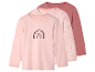 Trois t-shirts manches longues pour filles, dans des tons rose clair et rose terre, avec des motifs arc-en-ciel et cœurs.