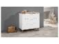 Une commode blanche avec trois tiroirs et des pieds en bois