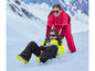 Deux enfants en tenue de ski jouent dans la neige.