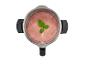 Vue de dessus d'un mixeur avec un smoothie rose et une garniture de menthe.