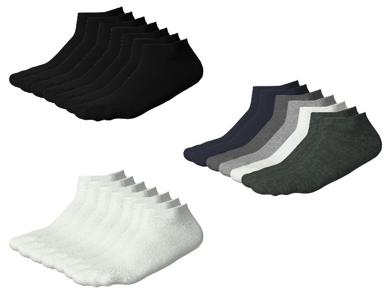 Trois paquets de chaussettes: noires, blanches et nuances de gris.