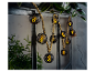 Guirlande lumineuse avec lanternes noires et corde en jute.