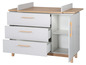 Commode blanche avec trois tiroirs, une porte et un plan à langer.