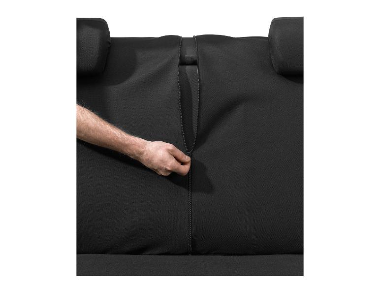 Main fermant la fermeture éclair d'une housse de siège auto noire