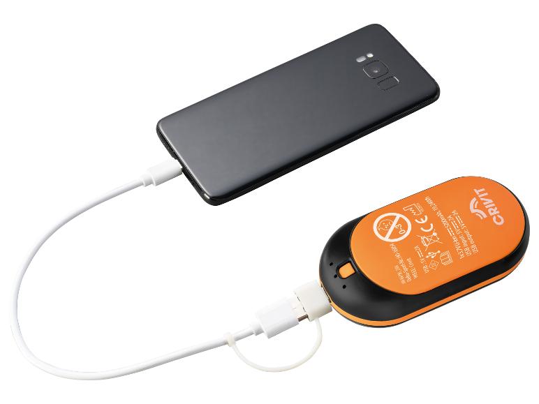Un smartphone noir est connecté à une batterie externe orange et noire via un câble USB blanc.