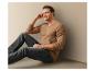 Un homme portant un pull marron et un jean bleu.