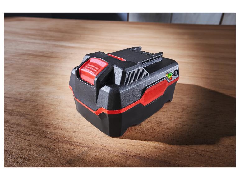 Batterie noire et rouge pour outils sur surface en bois.
