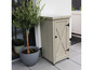 Un placard en bois gris avec une porte en forme de X, sur une terrasse.