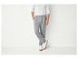 Homme portant un pantalon de survêtement gris et des baskets blanches.