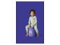 Enfant en pyjama rayé vert clair assis sur un tabouret en peluche violet en forme d'ours.