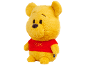 Peluche ours jaune doux portant un t-shirt rouge avec du texte brodé.