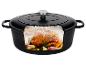 Cocotte en fonte noire avec un poulet rôti, de l'ail et des herbes à l'intérieur.
