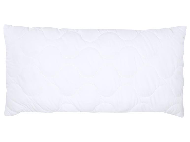 Oreiller blanc matelassé avec un motif ondulé