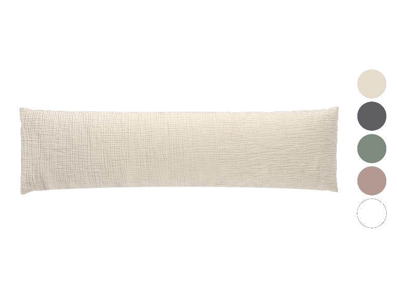 Long oreiller corporel texturé beige avec des échantillons de couleur sur le côté.