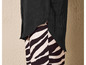 Une chemise noire à manches longues portée sur un pantalon à imprimé zèbre.