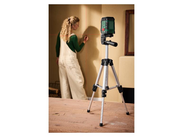 Femme marquant un mur avec un niveau laser Parkside sur trépied.