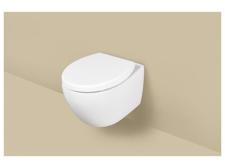 WC suspendu blanc avec abattant sur un mur beige.