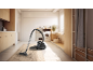 Aspirateur sur un tapis sale dans une buanderie lumineuse.