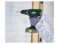 Un homme utilise une perceuse-visseuse Parkside sans fil pour percer un mur.