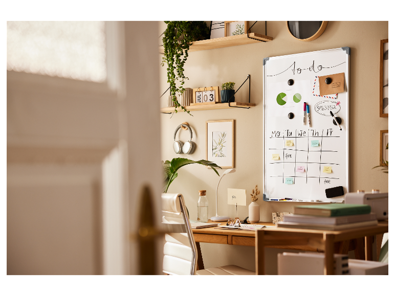 Tableau blanc, bureau organisé avec plantes et casque audio.