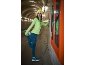 Femme en tenue de sport et bonnet lumineux s'étirant dans un tunnel.