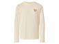 Sweat-shirt crème à manches longues avec un cœur rose sur la poitrine.