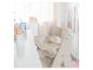 ROBA Treppenhochstuhl Sit Up: chaise haute bébé beige à côté d'une table blanche avec jouets.