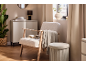 Coin lecture douillet avec fauteuil clair, plaid et table d'appoint.