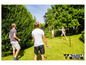 Quatre personnes jouent au badminton dans le jardin avec un filet Talbot Torro.