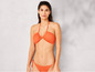 Une femme en bikini orange sur un fond gris.