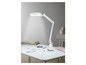 Une lampe de bureau blanche avec une loupe au-dessus d'une table avec des accessoires de couture.