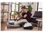 Un homme nettoie un coussin avec un nettoyeur vapeur Kärcher.