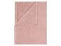Couverture polaire rose pliée, avec un côté lisse et un côté texturé.
