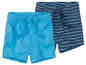 Deux shorts bleus pour garçons, un uni et un avec des vagues.