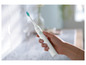 Une main tient une brosse à dents électrique Philips Sonicare.