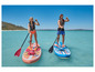 Deux personnes pagayant sur des paddleboards gonflables dans une eau turquoise.