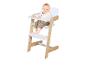 Un bébé souriant assis dans une chaise haute en bois et blanche avec plateau.