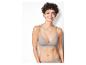Une femme porte un soutien-gorge et une culotte beiges.