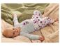 Bébé allongé sur le dos, portant un body bleu clair et un pantalon à pois.