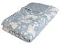 Couette matelassée bleu clair à motifs floraux.