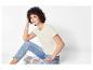 Une femme portant un t-shirt blanc et un jean bleu.