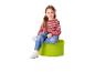 Fille assise sur un pouf vert, vêtue d'un pull rayé et d'un jean.