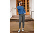 Une femme portant un pull bleu et un pantalon gris.