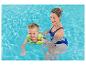 Mère et enfant dans une piscine, l'enfant portant un gilet de sauvetage.