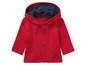 Un sweat-shirt rouge à capuche et à boutons pour bébé.