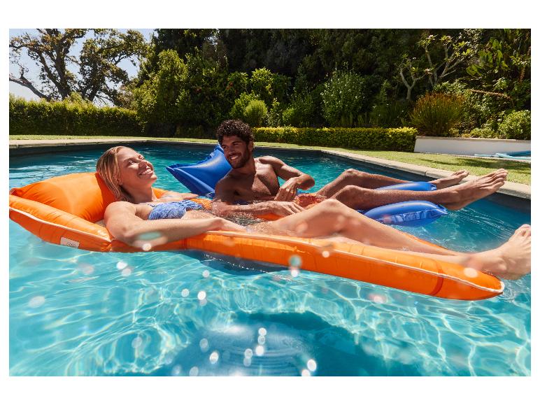 Couple se relaxant sur des matelas gonflables orange et bleus dans une piscine.